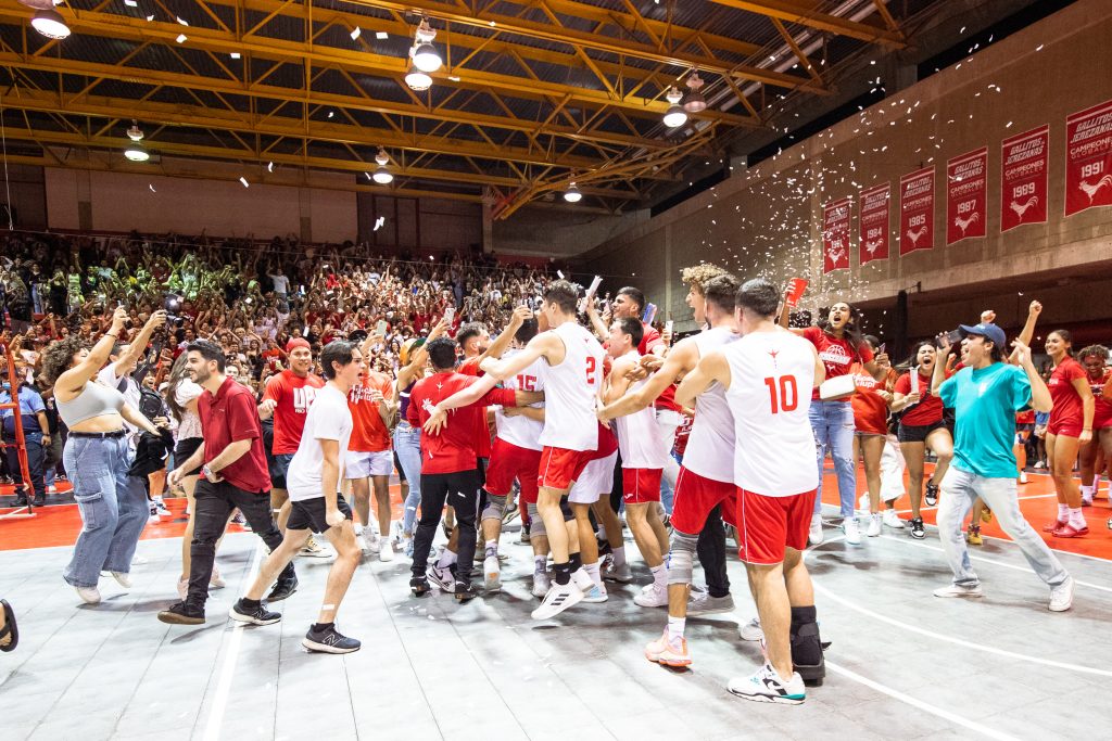 El equipo de voleibol masculino y la fanaticada del Recinto de Río Piedras celebran su campeonato en la cancha