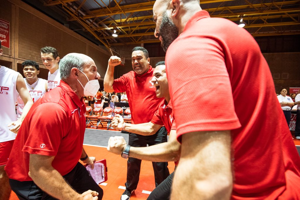 El cuerpo técnico del equipo de voleibol masculino y la fanaticada del Recinto de Río Piedras celebran su campeonato en la cancha