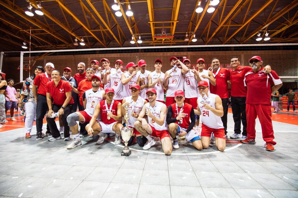 Equipo de voleibol masculino del Recinto de Río Piedras posa con las medallas oro y la copa del campeonato