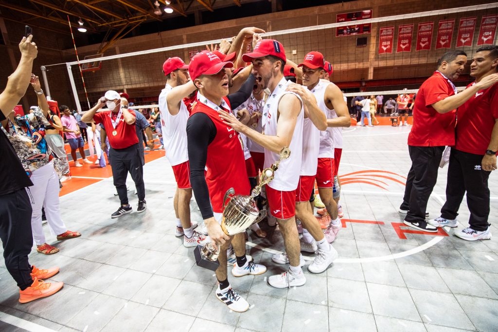 Equipo de voleibol masculino del Recinto de Río Piedras posa con las medallas oro y la copa del campeonato