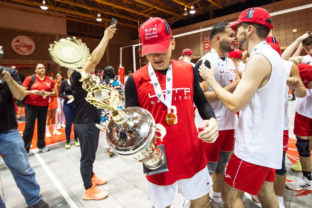 Equipo de voleibol masculino del Recinto de Río Piedras posa con las medallas oro y la copa del campeonato