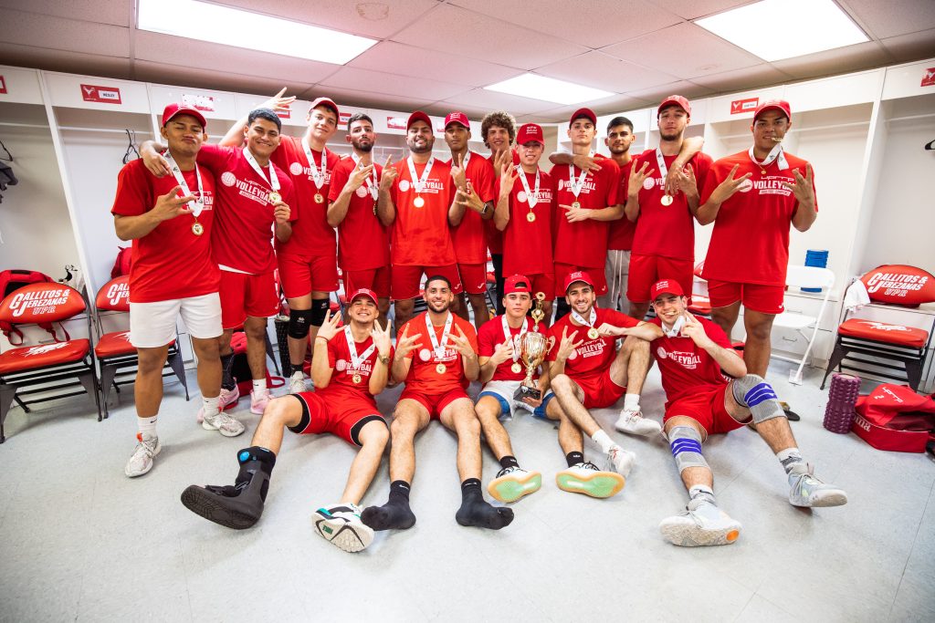 Equipo de voleibol masculino del Recinto de Río Piedras posa con las medallas oro y la copa del campeonato