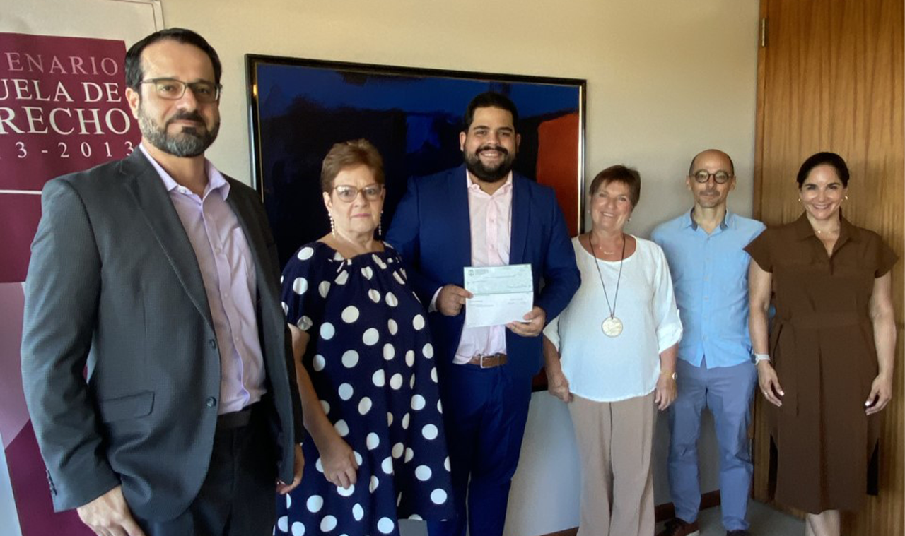 En la foto de izquierda a derecha Decano Interino, Oscar Miranda Miller, Esther Alvarado Viuda de Reyes Gilestra, Estudiante Roberto Sostre Carrasquillo, Directora Ejecutiva del Fideicomiso para la Escuela de Derecho UPR, Lcda. María de los A. Garay, Presidente de Amigos de la Escuela de Derecho UPR, Lcdo. Hiram Angueira Quirós y Lcda. Elsa Jiménez Pérez de Amigos de la Escuela de Derecho UPR.