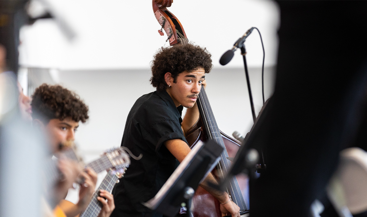 Portada de estudiante de la banda tocando el bajo