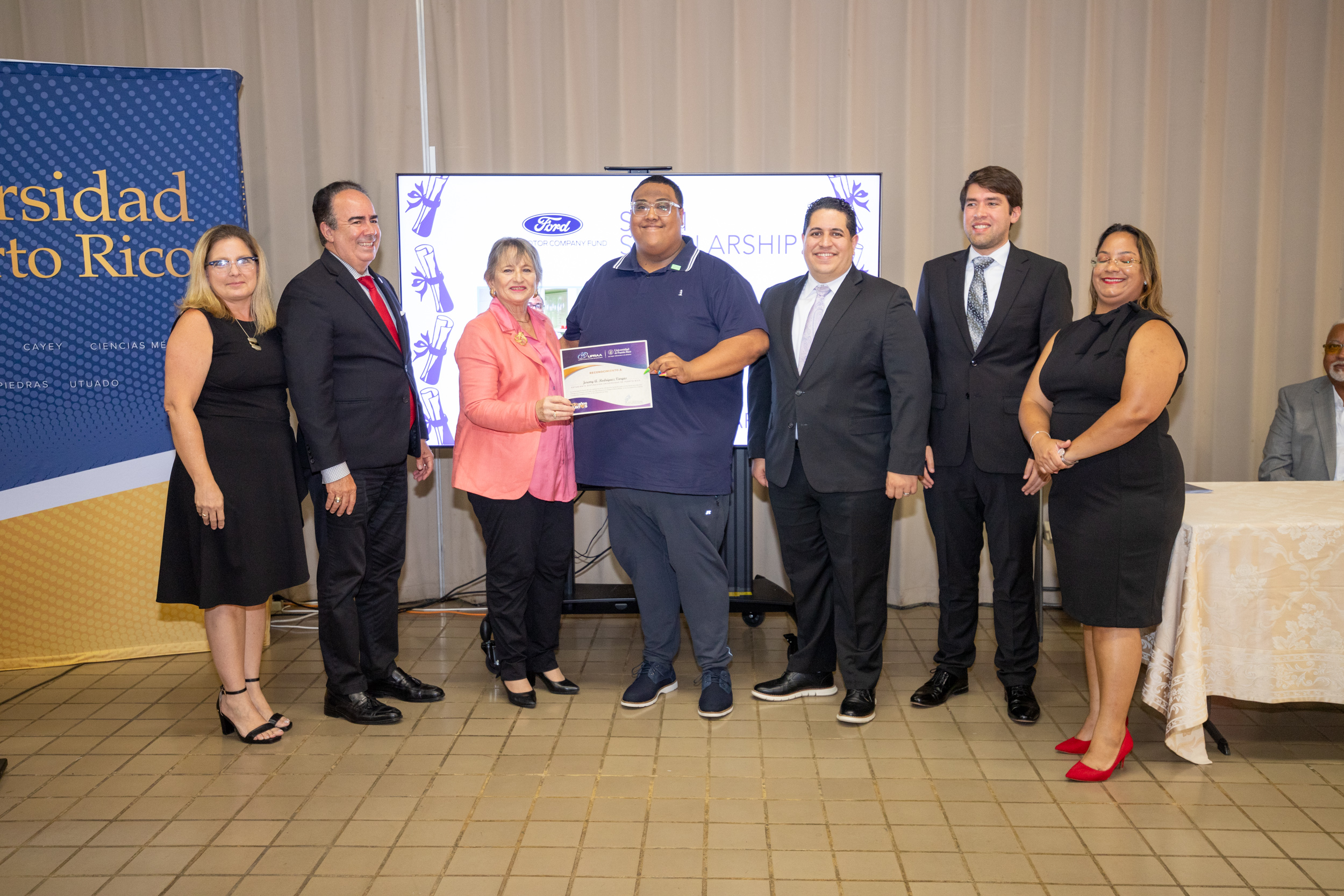 Jeremy A. Rodríguez Vargas recibe la beca respaldada por Ford Motor Company Fund, junto a funcionarios de la UPR y representantes de UPRAA