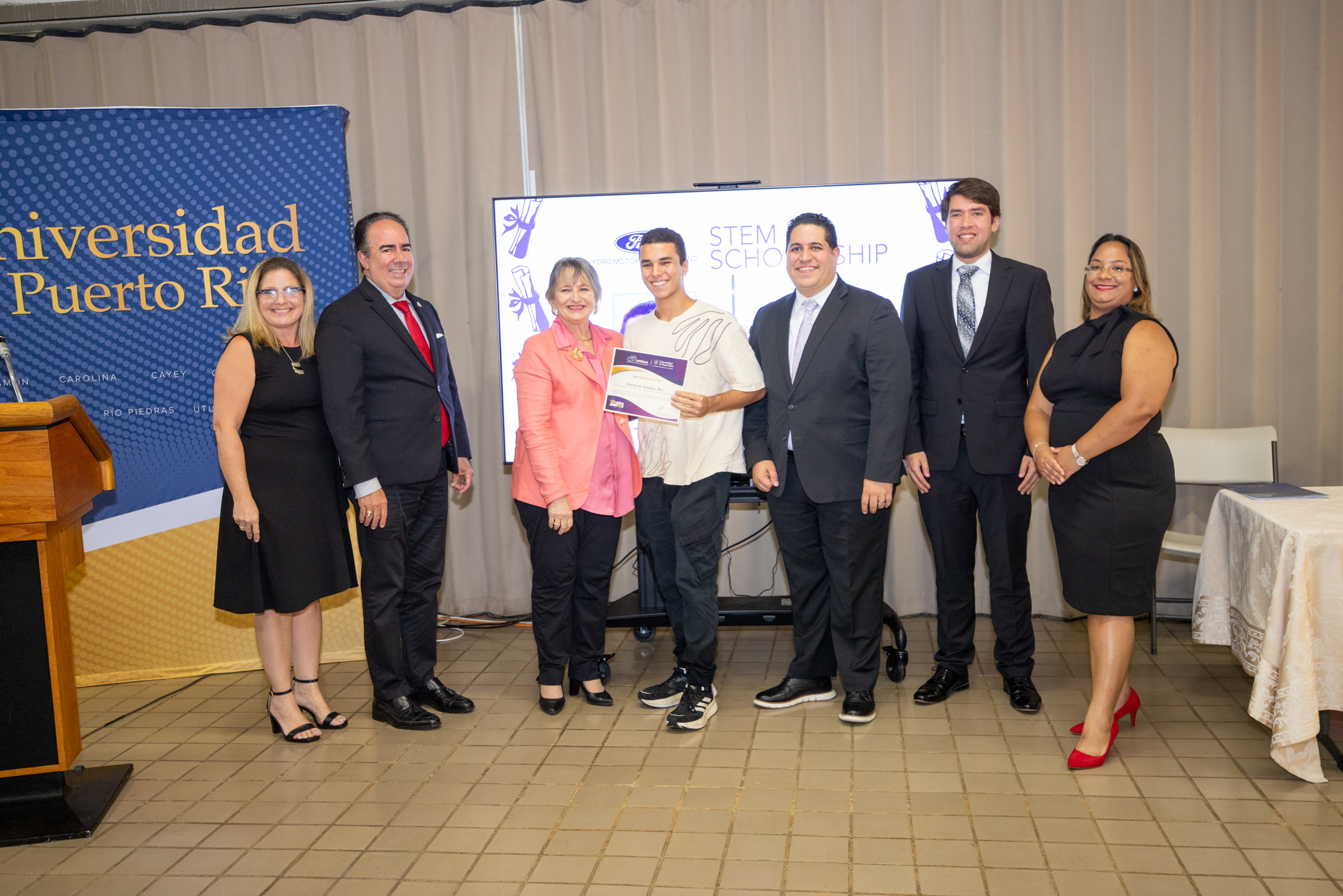 Sebastián Gabriel Rodríguez recibe la beca respaldada por Ford Motor Company Fund, junto a funcionarios de la UPR y representantes de UPRAA